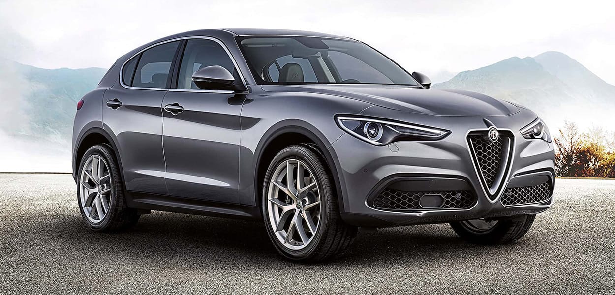 Grauer Alfa Romeo Stelvio steht auf einer Straße.