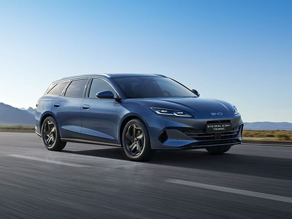 Weißes Auto BYD Seal 06 fährt über eine Straße