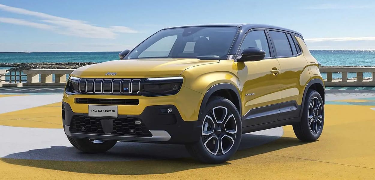 Ein gelb-schwarzer Jeep Avenger steht am Meer auf einem gelb-weißen Untergrund.