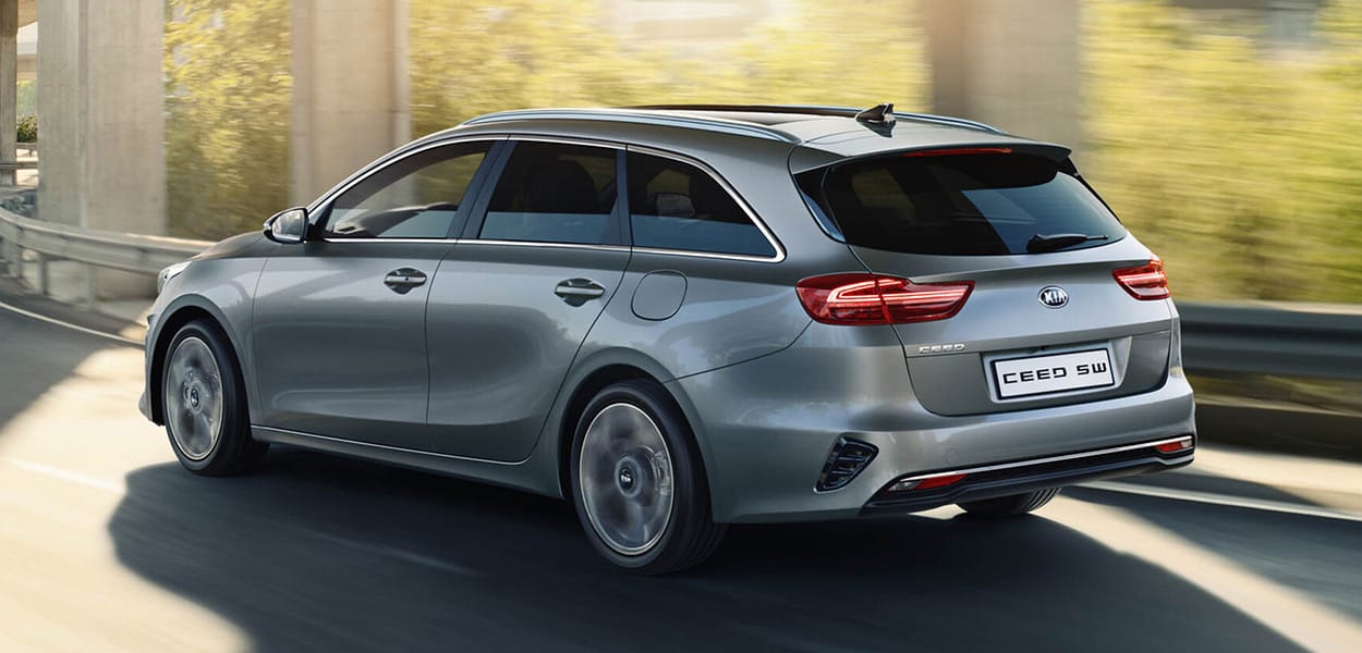 Aufnahme schräg von hinten eines Kia Ceed Sportswagon in Grau bei der Fahrt durch eine Unterführung.