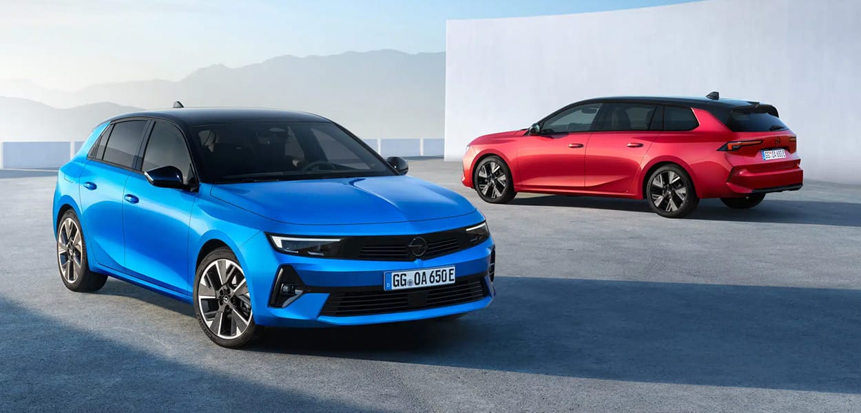 Ein blauer Opel Astra und ein roter Opel Astra Kombi stehen auf einem Platz vor einem hellen Gebäude.