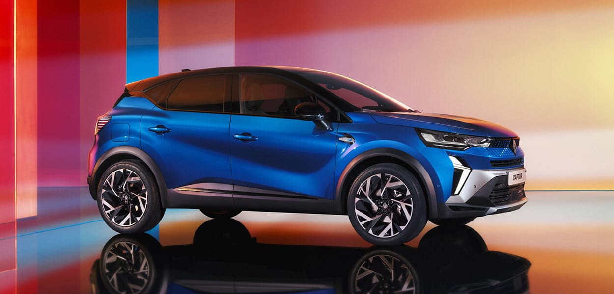 Seitenansicht eines blauen Renault Captur vor einer bunten Design-Kulisse.