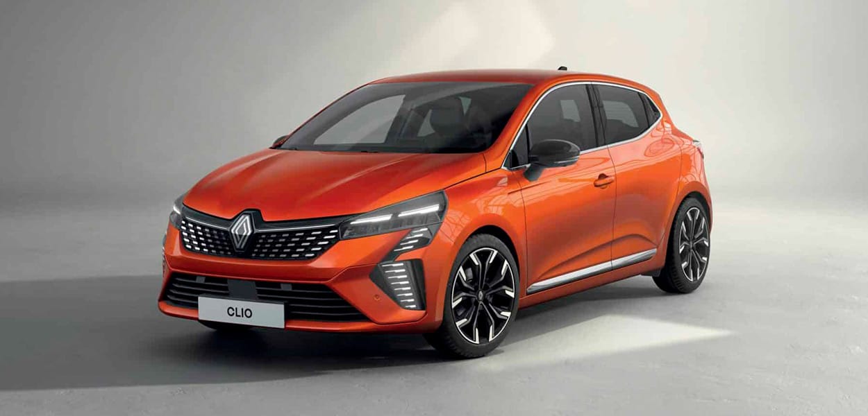 Ein orangener Renault Clio parkt in einer hellgrauen Umgebung.