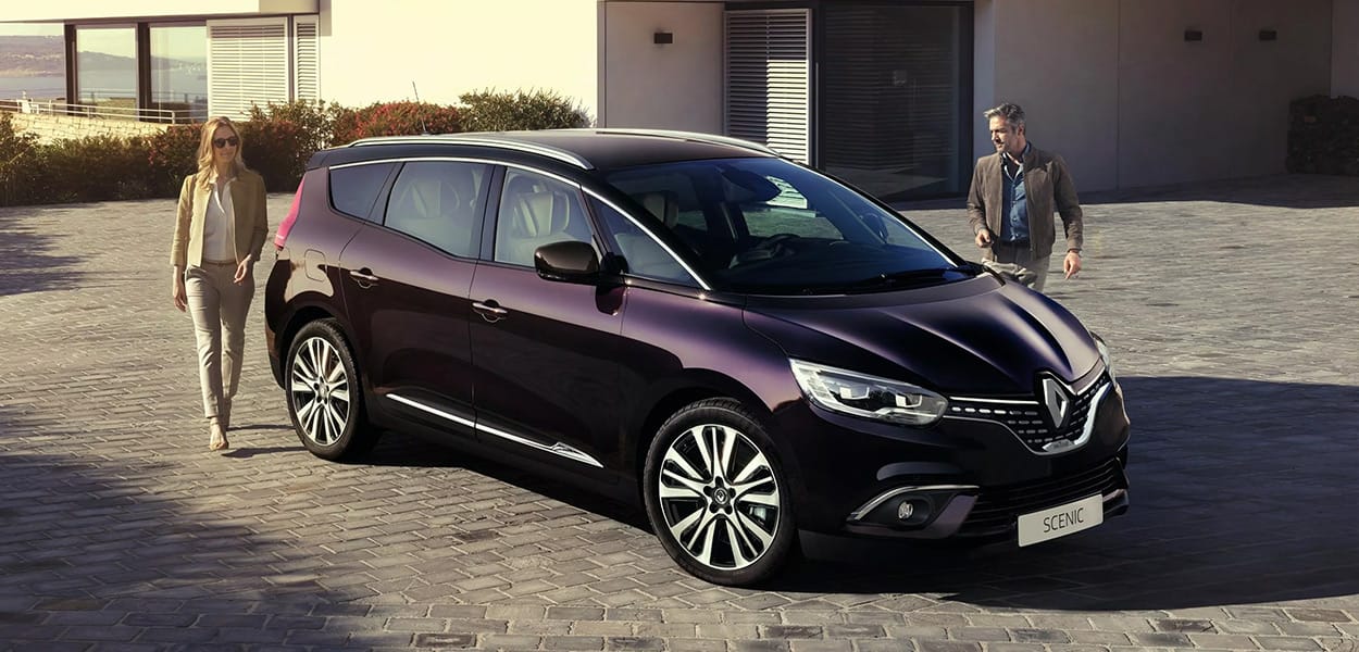 Ein Pärchen steigt in einen vor einem Haus geparkten, violetten Renault Scenic.
