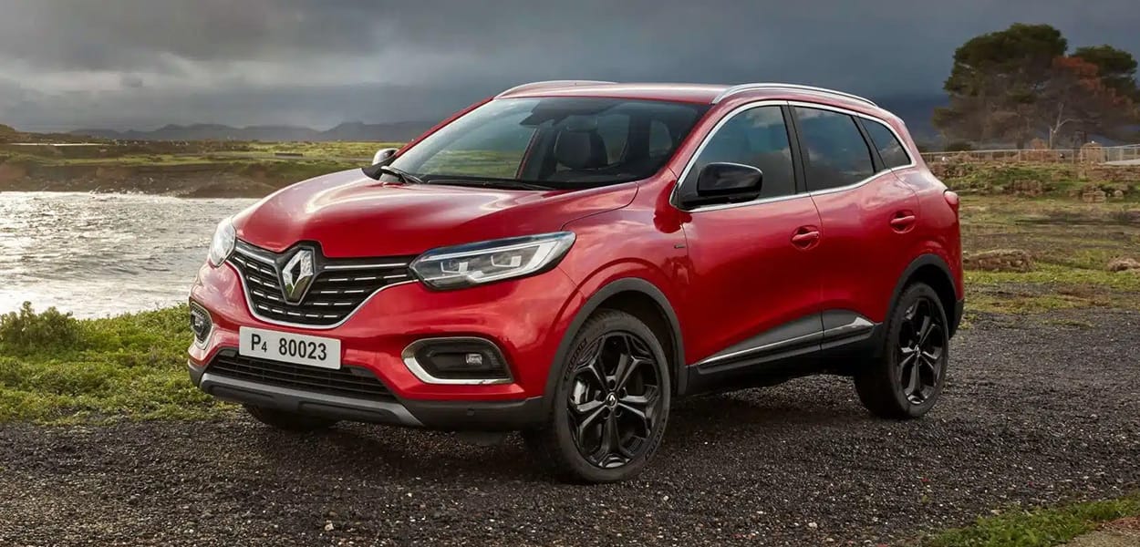 Ein roter Renault Kadjar steht in einer idyllischen Landschaft an einem See.