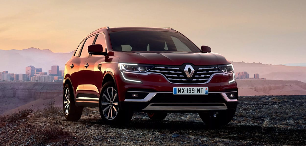 Ein dunkelroter Renault Koleos parkt auf einem Berg mit beeindruckender Bergkulisse.