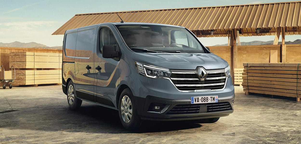 Ein grauer Renault Trafic parkt auf dem Platz einer Holz-Werkstatt.