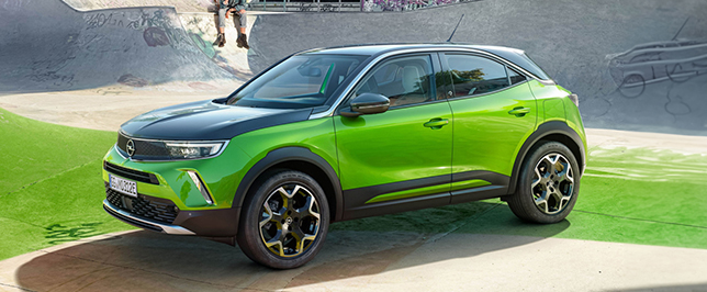Grün-schwarzer Opel Mokka auf einem Sportplatz.